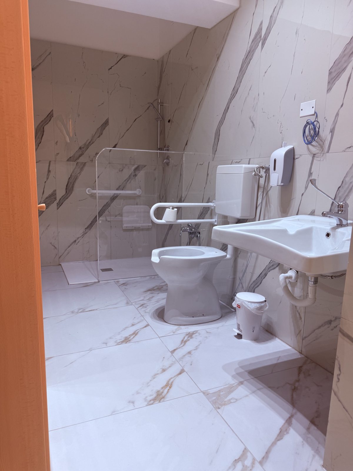 Bagno assistito con doccia a filo pavimento e maniglioni di sicurezza