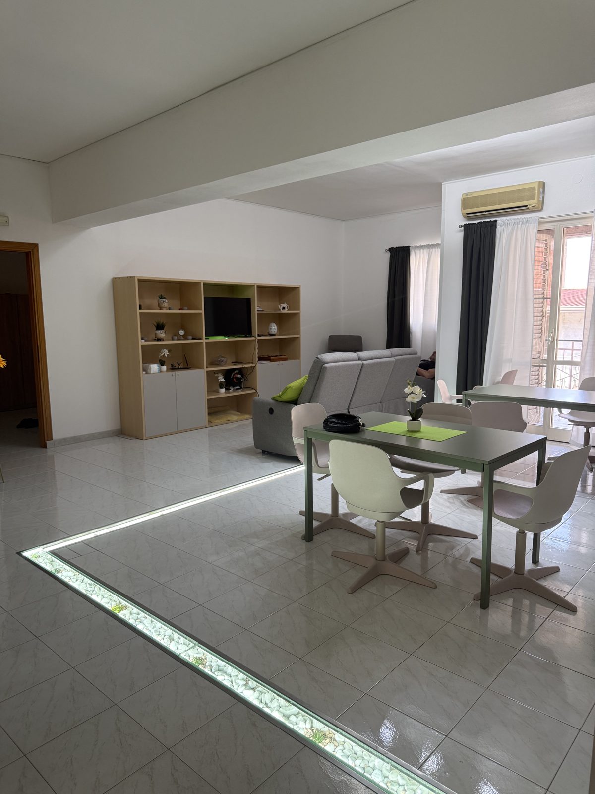 Ampia zona giorno luminosa con divani, tavoli e area pranzo